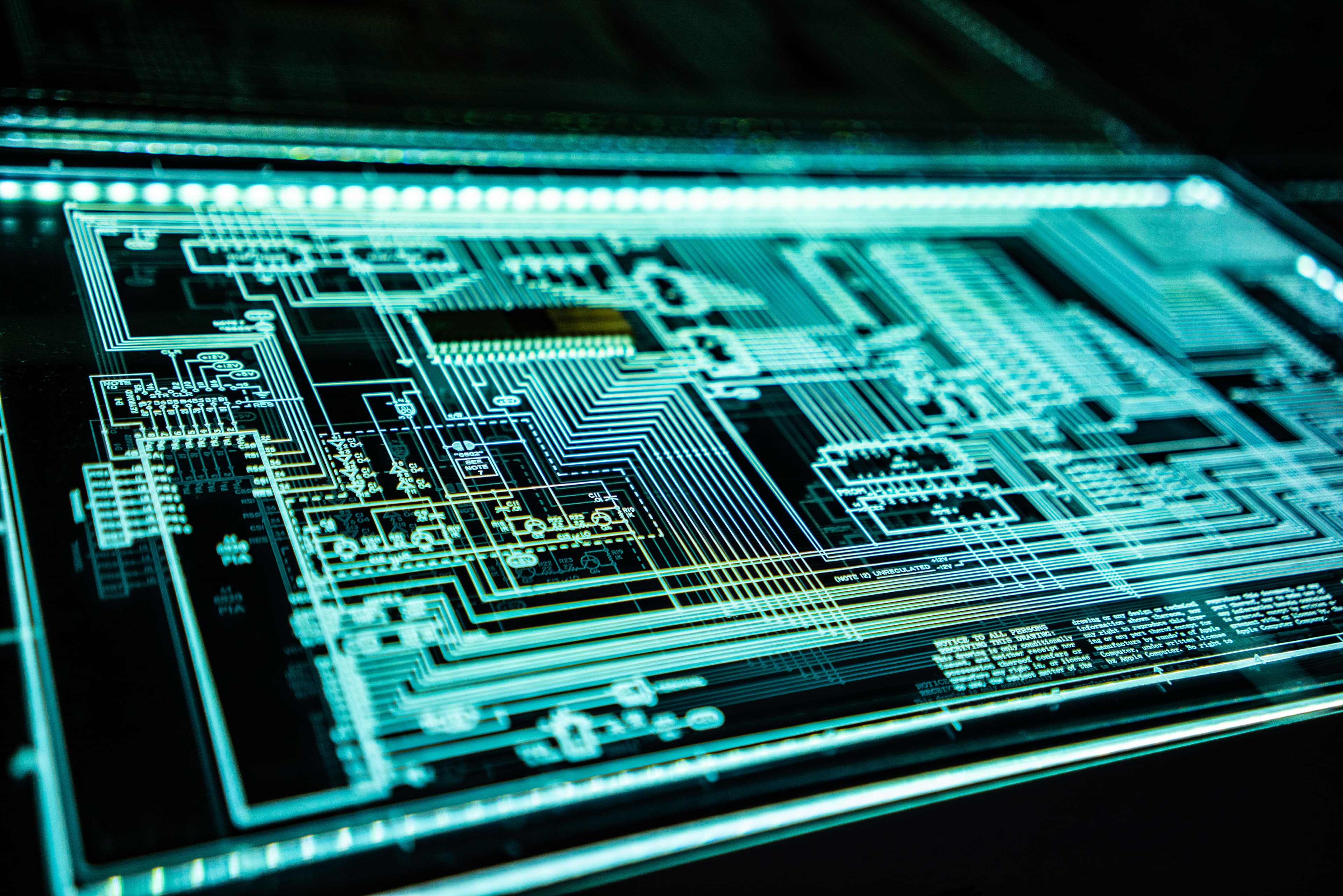 Close view of a glowing circuit board and technical system diagram