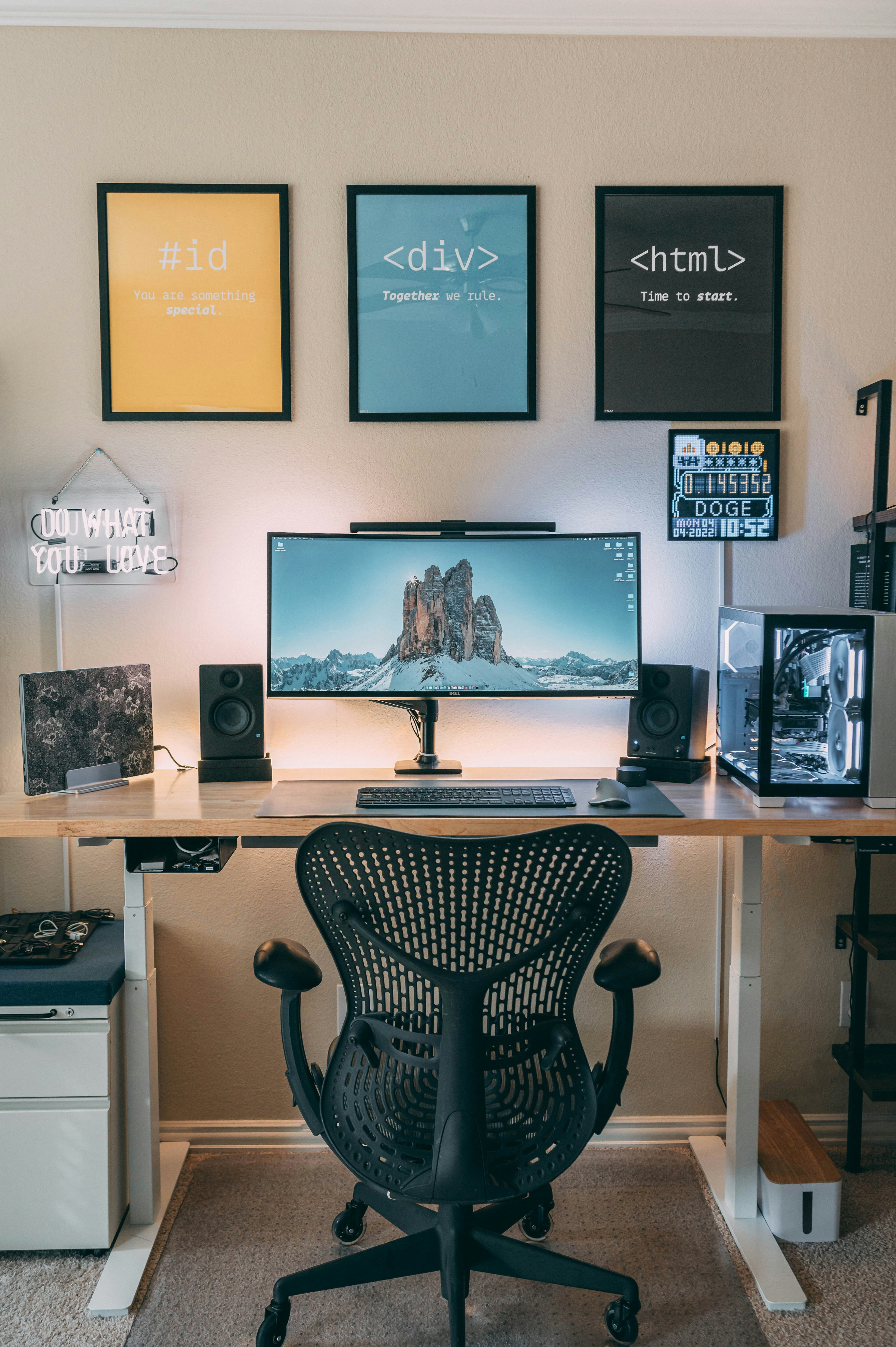 A complete development workstation with a monitor, computer and code-themed wall art